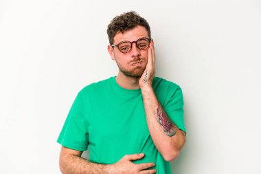 Beyaz arka planda izole olmuş beyaz tenli genç adamın yanakları şişer, yorgun bir ifadesi vardır. Yüz ifadesi kavramı.