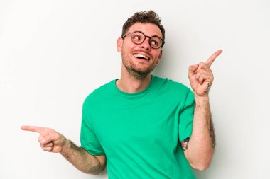 Beyaz arka planda izole edilmiş genç beyaz bir adam farklı kopya alanlarını gösteriyor, birini seçiyor, parmaklarıyla gösteriyor..