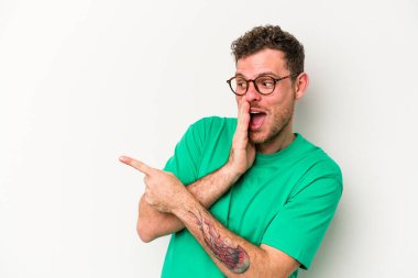 Beyaz arka planda izole edilmiş genç beyaz bir adam bir dedikodu söylüyor, bir haber sunuyor..