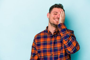 Kafkasyalı genç adam mavi arka planda yalnızdı gülerek, kaygısızca, doğal duygularla.