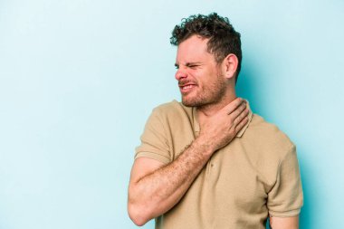 Kafkasyalı genç adam mavi arka planda izole edilmiş kafasının arkasına dokunuyor, düşünüyor ve bir seçim yapıyor..