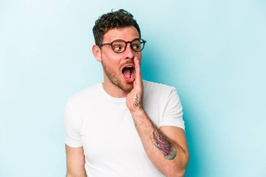 Mavi arka planda izole edilmiş beyaz bir adam heyecanlı bir şekilde bağırıyor..