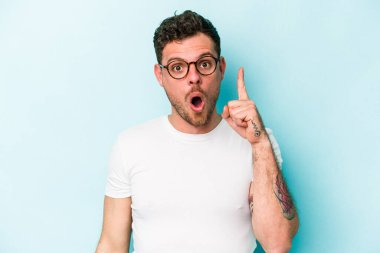 Mavi arka planda izole edilmiş beyaz bir adam ağzı açık bir şekilde üst tarafı işaret ediyor..