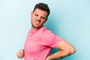 Mavi arka planda izole edilmiş beyaz bir adam sırt ağrısı çekiyor..