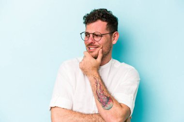 Mavi arka planda izole edilmiş genç beyaz adam virüs ya da enfeksiyon yüzünden boğazında ağrı hissediyor..