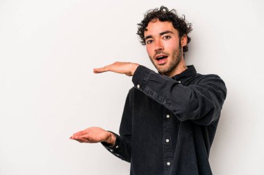 Beyaz arka planda izole edilmiş genç beyaz adam elleri arasında bir kopya alanı tutarken şok ve hayrete düştü..