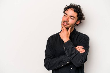 Beyaz arka planda izole edilmiş genç beyaz bir adam rahatlamış bir şeyin fotokopi odasına baktığını düşünüyor..