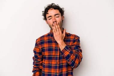 Beyaz arka planda izole edilmiş genç beyaz adam esniyor. Ağzı eliyle kapatan yorgun bir hareket sergiliyor..