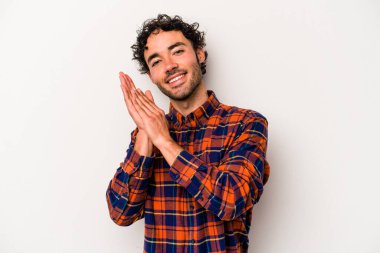 Beyaz arka planda izole olmuş genç beyaz bir adam enerjik ve rahat hissediyor, ellerini ovuşturuyor..