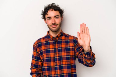 Beyaz arka planda izole edilmiş genç beyaz bir adam gülümseyerek beş numarayı parmaklarıyla gösteriyor..