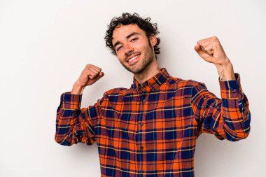 Beyaz arka planda izole genç beyaz adam özel bir günü kutluyor, atlıyor ve enerjiyle kollarını kaldırıyor..