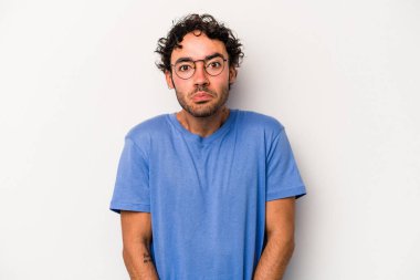 Beyaz arka planda izole edilmiş genç beyaz bir adam omuz silkiyor ve gözleri açık..