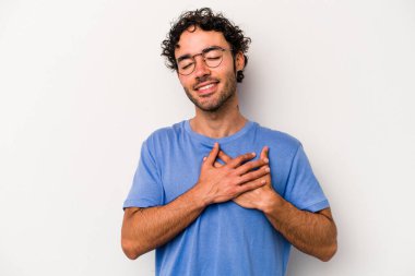 Beyaz arka planda izole edilmiş beyaz tenli genç bir adam, dostane bir ifadeye sahip, avuçlarını göğsüne bastırıyor. Aşk konsepti.