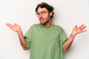 Beyaz arka planda izole edilmiş genç beyaz bir adam. Kafası karışmış ve omuz silkiyor. Kopya alanını tutmak için..