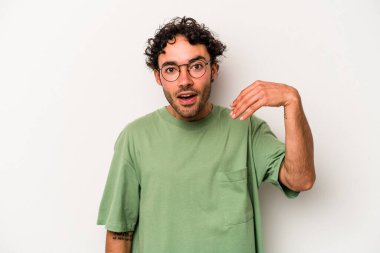 Beyaz arka planda izole olmuş genç beyaz bir adam bir şeye gülüyor, ağızlarını ellerle kapatıyor..