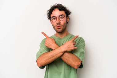 Beyaz arka plan noktalarında izole genç beyaz adam, iki seçenek arasında seçim yapmaya çalışıyor.