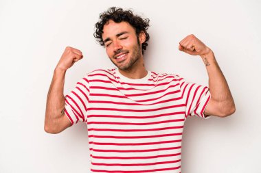 Beyaz arka planda izole genç beyaz adam özel bir günü kutluyor, atlıyor ve enerjiyle kollarını kaldırıyor..