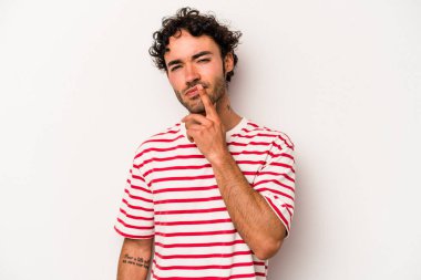 Beyaz arka planda soyutlanmış genç beyaz bir adam düşünüyor ve yukarı bakıyor, yansıtıyor, düşünüyor, hayal kuruyor..