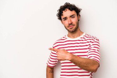 Beyaz arka planda izole edilmiş genç beyaz adam yan tarafı işaret ediyor