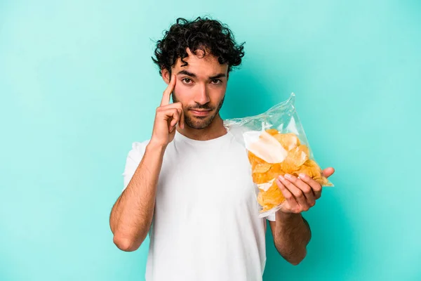 Jonge Blanke Man Met Een Zak Chips Geïsoleerd Blauwe Achtergrond — Stockfoto
