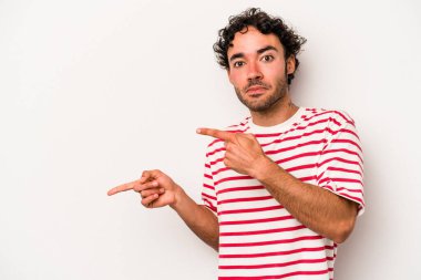 Beyaz arka planda izole edilmiş genç beyaz bir adam işaret parmağıyla fotokopi alanını işaret ederek şok oldu..