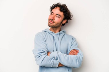 Beyaz arka planda izole edilmiş genç beyaz adam hedeflere ve amaçlara ulaşmayı hayal ediyor.