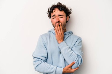 Beyaz arka planda izole edilmiş genç beyaz adam esniyor. Ağzı eliyle kapatan yorgun bir hareket sergiliyor..