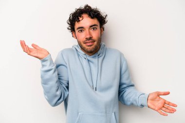 Beyaz arka planda izole edilmiş genç beyaz bir adam. Kafası karışmış ve omuz silkiyor. Kopya alanını tutmak için..
