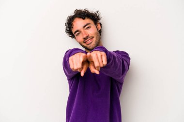 Beyaz arka planda izole edilmiş genç beyaz adam parmaklarıyla ön tarafı işaret ediyor..