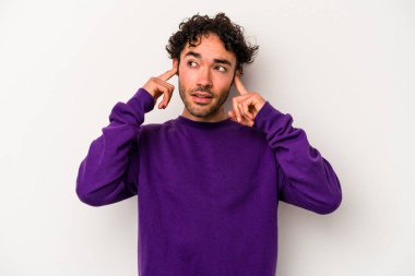 Beyaz arka planda izole edilmiş genç beyaz bir adam parmaklarıyla kulaklarını kapatıyor, gürültülü bir ortam yüzünden stresli ve çaresiz..