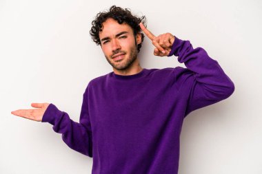 Beyaz arka planda izole edilmiş genç beyaz bir adam elinde bir ürün tutuyor ve.