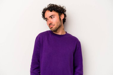 Beyaz arka planda izole edilmiş genç beyaz bir adam omuz silkiyor ve gözleri açık..