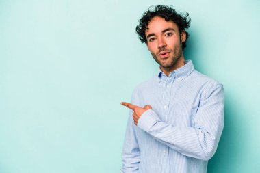 Beyaz arka planda izole edilmiş genç beyaz adam yan tarafı işaret ediyor
