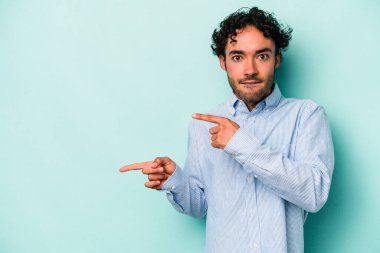 Beyaz arka planda izole edilmiş genç beyaz bir adam işaret parmağıyla fotokopi alanını işaret ederek şok oldu..
