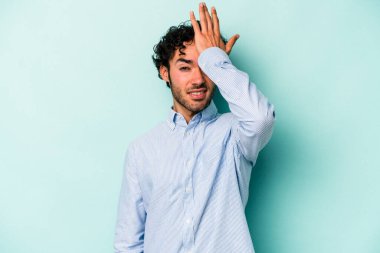 Beyaz arka planda izole edilmiş genç beyaz bir adam bir şeyi unutuyor. Alnına avuç içi ve gözlerini kapayarak vuruyor..