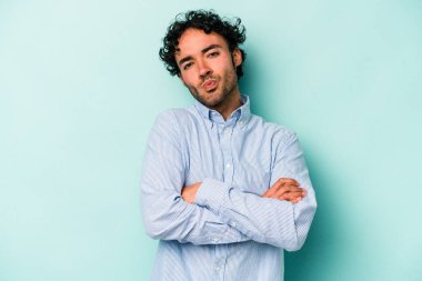 Beyaz arka planda izole edilmiş, hoşnutsuzca kaşlarını çatmış, kollarını kavuşturmuş genç beyaz bir adam..