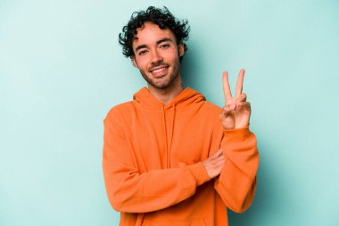 Beyaz arka planda izole edilmiş genç beyaz adam iki numarayı parmaklarıyla gösteriyor..