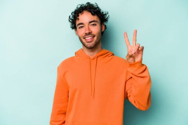 Beyaz arka planda izole edilmiş genç beyaz bir adam neşeli ve kaygısız parmakları olan bir barış sembolü gösteriyor..