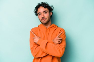 Beyaz arka plan noktalarında izole genç beyaz adam, iki seçenek arasında seçim yapmaya çalışıyor.