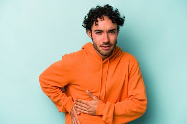 Beyaz arka planda karaciğer ağrısı çeken, karnı ağrıyan genç beyaz bir adam..