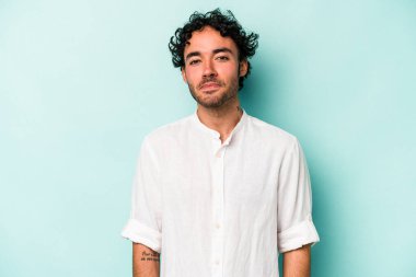 Beyaz arka planda izole edilmiş genç beyaz bir adam omuz silkiyor ve gözleri açık..