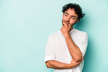 Beyaz arka planda izole edilmiş genç beyaz bir adam rahatlamış bir şeyin fotokopi odasına baktığını düşünüyor..