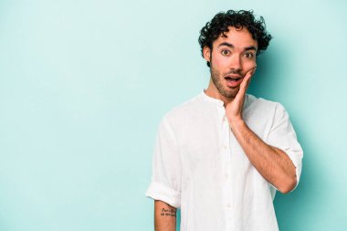 Beyaz arka planda izole genç beyaz adam yüksek sesle bağırıyor, gözleri açık ve elleri gergin tutuyor..