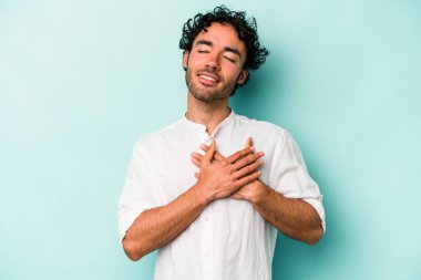 Beyaz arka planda izole edilmiş beyaz tenli genç bir adam, dostane bir ifadeye sahip, avuçlarını göğsüne bastırıyor. Aşk konsepti.