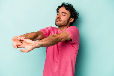 Beyaz arka planda izole edilmiş genç beyaz adam kollarını uzatıyor, rahat bir konumda..