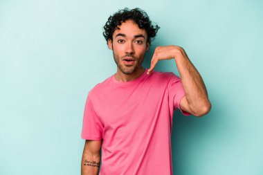 Beyaz arka planda izole olmuş genç beyaz bir adam bir şeye gülüyor, ağızlarını ellerle kapatıyor..