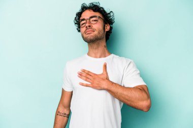 Beyaz arka planda izole edilmiş genç beyaz adam yemin ediyor, elini göğsüne koyuyor..