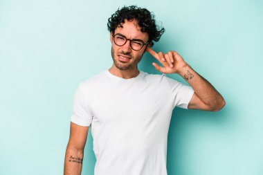 Beyaz arka planda izole edilmiş genç beyaz bir adam parmaklarıyla kulaklarını kapatıyor, gürültülü bir ortam yüzünden stresli ve çaresiz..