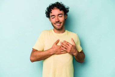 Beyaz arka planda izole edilmiş beyaz tenli genç bir adam, dostane bir ifadeye sahip, avuçlarını göğsüne bastırıyor. Aşk konsepti.