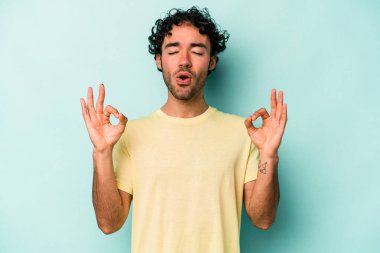 Beyaz arka planda izole edilmiş genç beyaz adam yoğun bir günün ardından rahatlıyor. Yoga yapıyor..